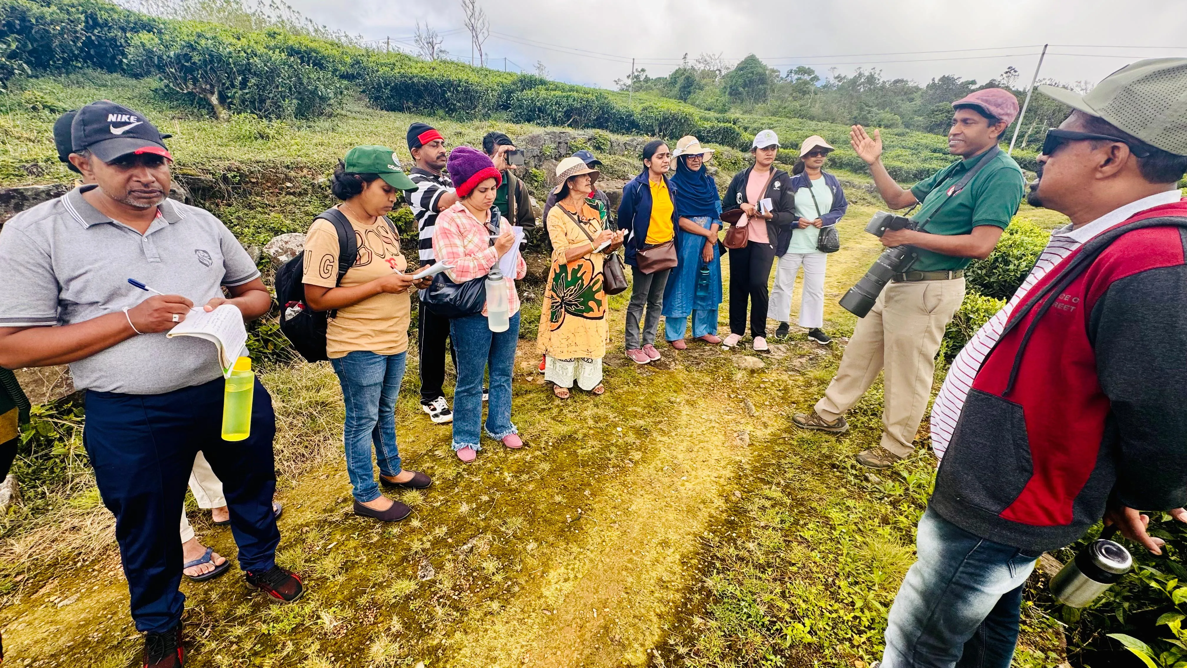 Nayana Pradeep leading a field session for the commissioners among tea bushes.
