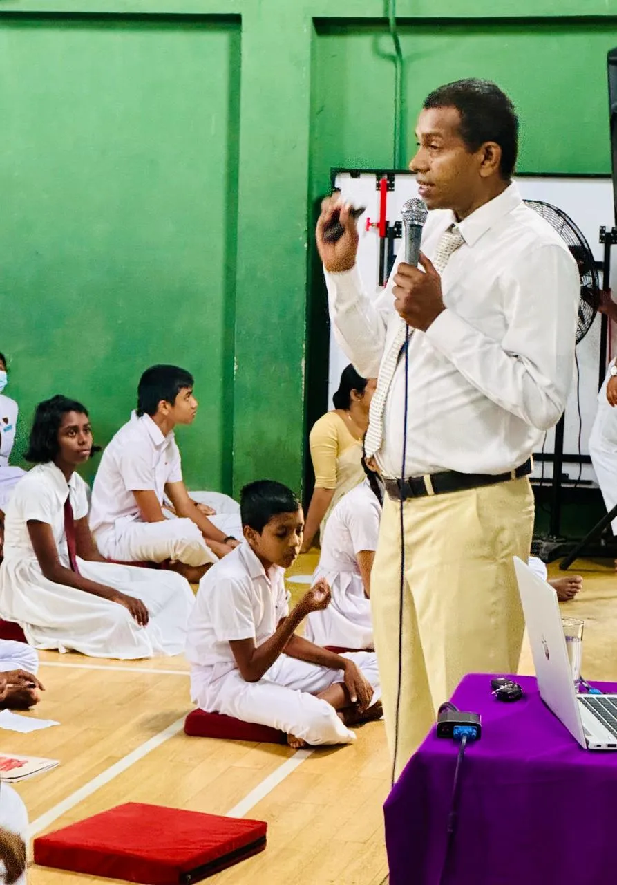 Nayana Pradeep addressing the students with a microphone during the mindfulness program.