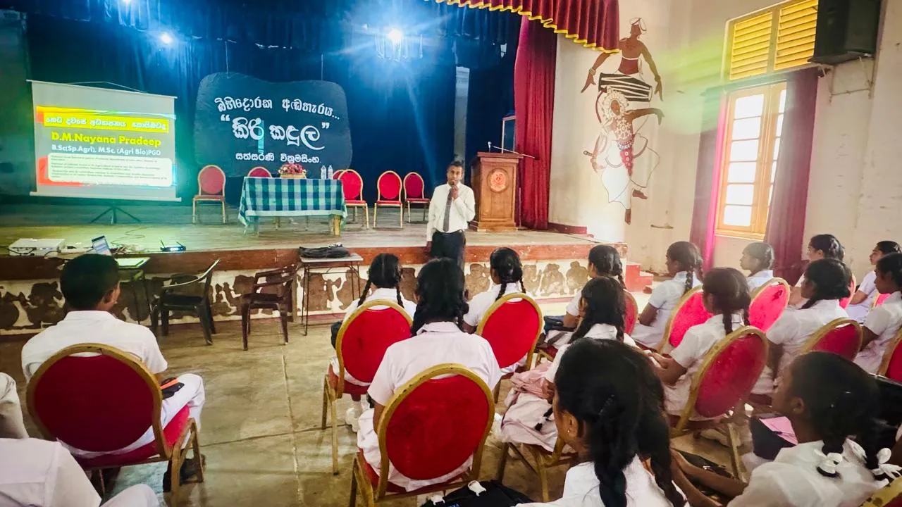 Nayana Pradeep presenting from the front of the hall to Advanced Level students at Poramadulla Central College.