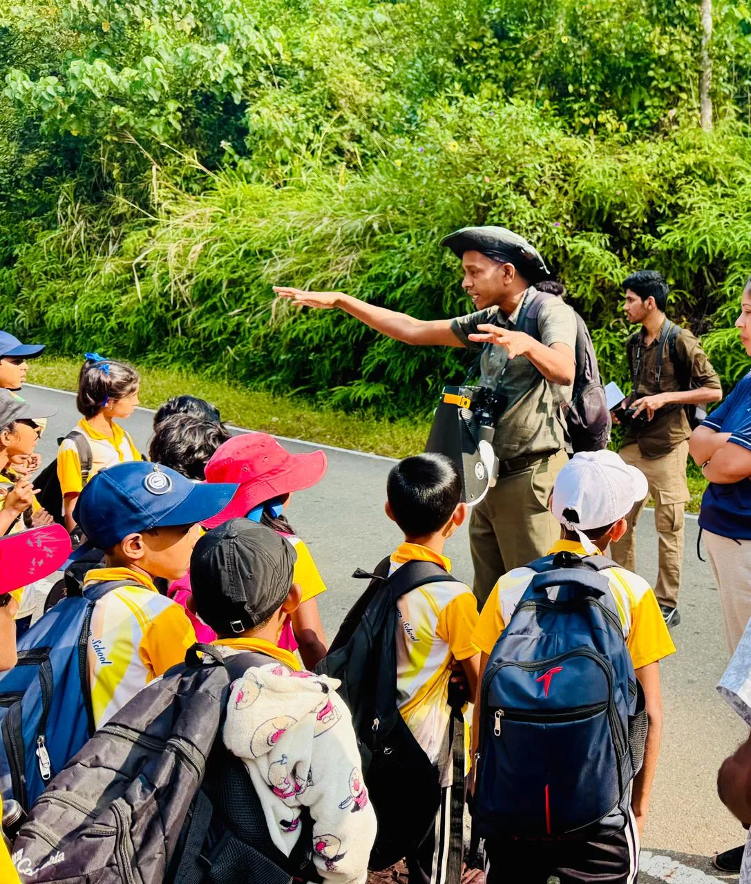 A naturalist guide explaining the forest to a group of students during the field trip.
