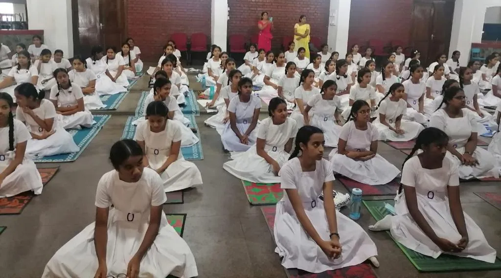 Students of Mahamaya Balika Vidyalaya seated on mats during the mindfulness programme.