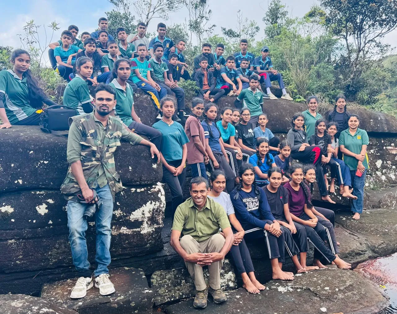 Group photograph of the students on rocks near Hadapan Ella, with Nayana Pradeep at the front.