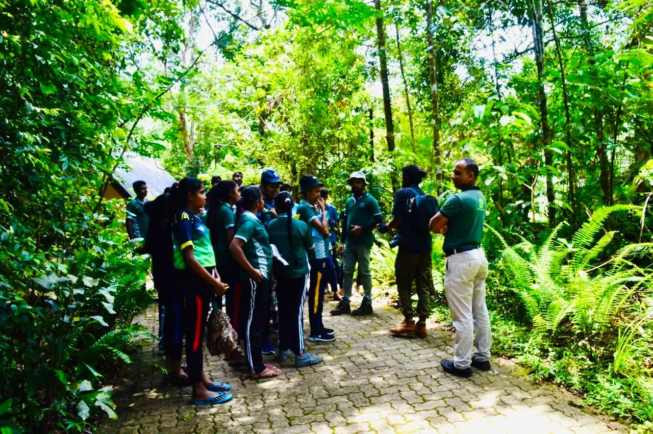 Nayana Pradeep talking with students and facilitators on a path through Sinharaja.