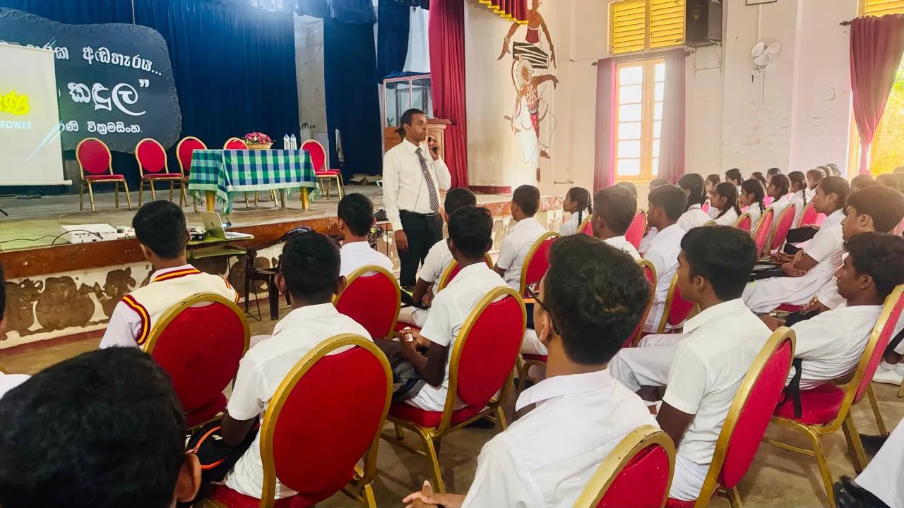 Nayana Pradeep speaking among students seated in the school hall.