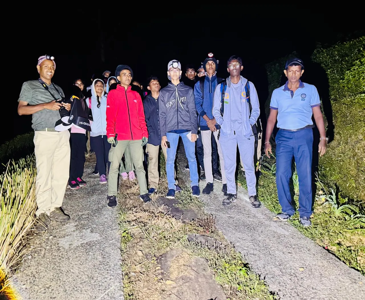 Group of students with headlamps during a night walk.