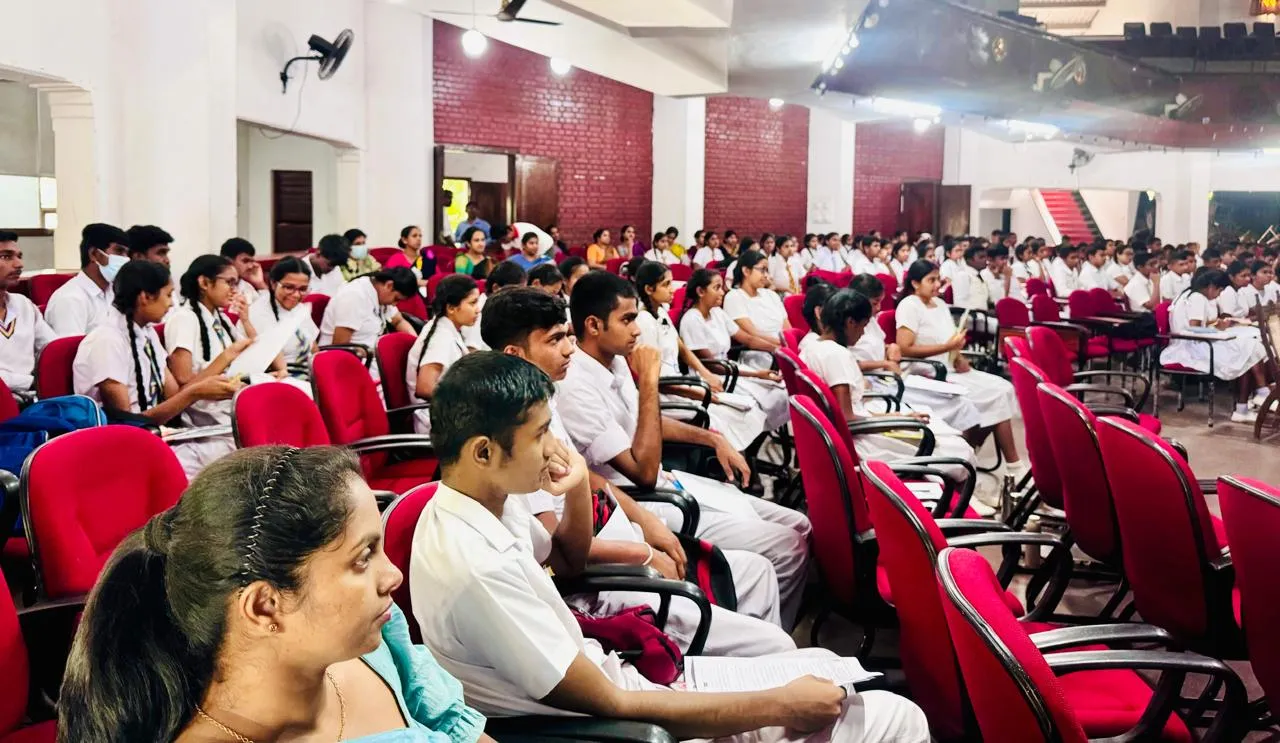 A wider view of students and teachers gathered in the Mahamaya auditorium.