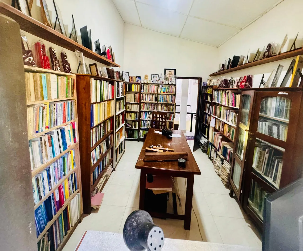 Inside Nayana’s personal research library — a reading room lined with book-filled shelves on both sides.