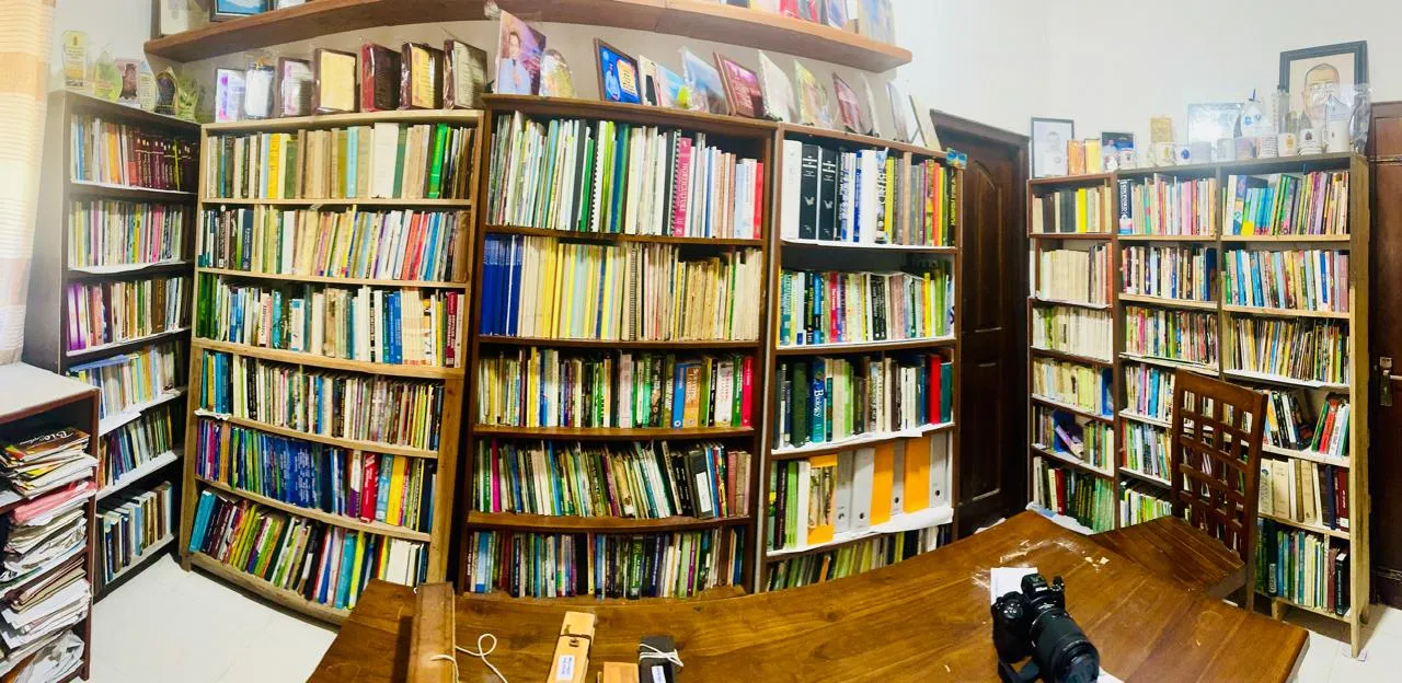 Curved wooden shelves packed floor to ceiling with books.